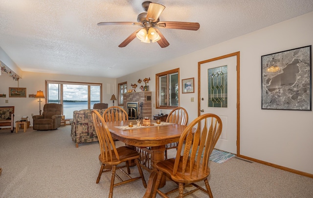 3925 Plainview Dr NW, Hackensack, MN 56452 - dining area featuring light carpet, a textured ceiling, a fireplace, and ceiling fan