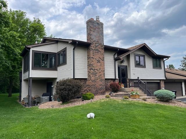 564 Donegal Cir, Shoreview, MN 55126 - view of front facade featuring a chimney, a front lawn, and driveway