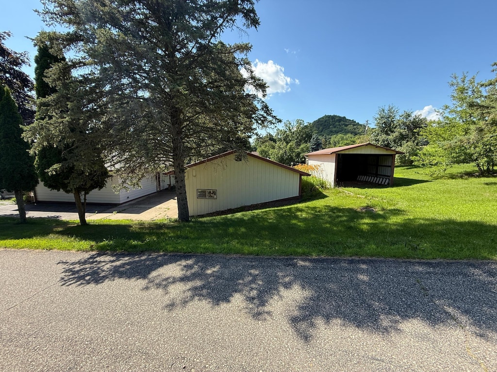 W12414 State Highway 35, Stockholm, WI 54769 - view of side of property with a lawn, a pole building, and an outbuilding