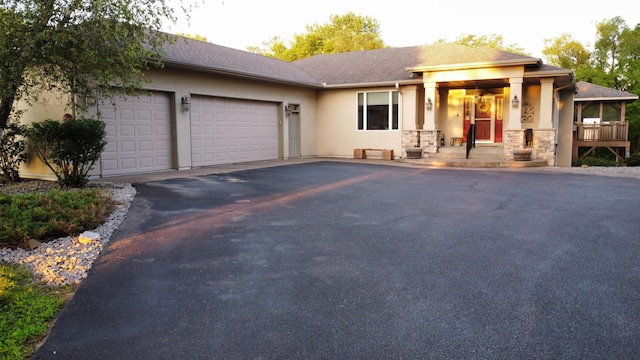 N7408 1195th St, Clifton Twp, WI 54022 - view of front facade featuring a garage, asphalt driveway, a porch, stucco siding, and stone siding