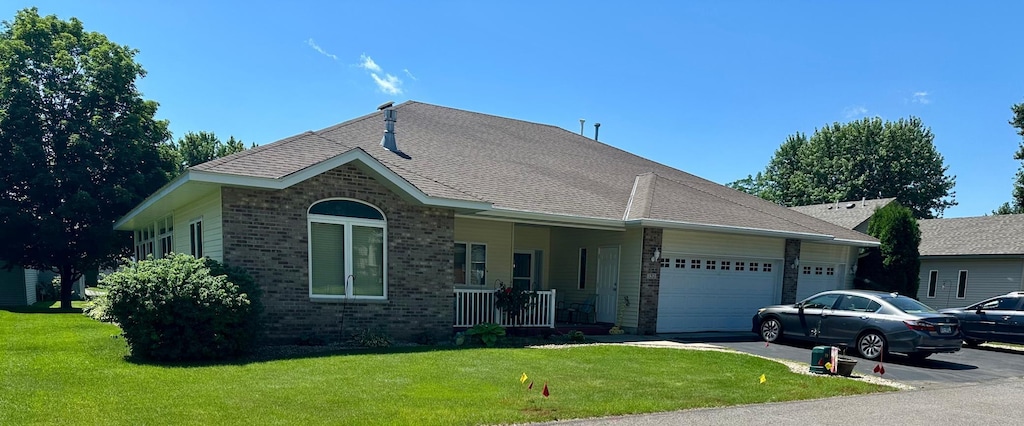 132 Goldfinch Ln, Clearwater, MN 55320 - ranch-style home with brick siding, covered porch, a garage, and a front lawn
