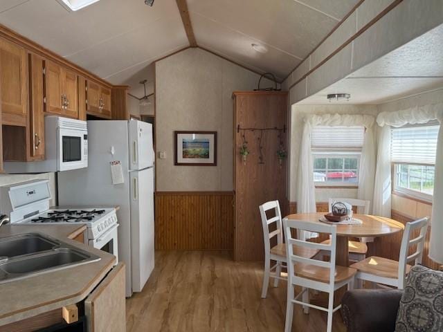 5055 Lake Mary Dr SW Unit 18, Alexandria, MN 56308 - kitchen with white appliances, light wood-style floors, vaulted ceiling, brown cabinets, and wainscoting