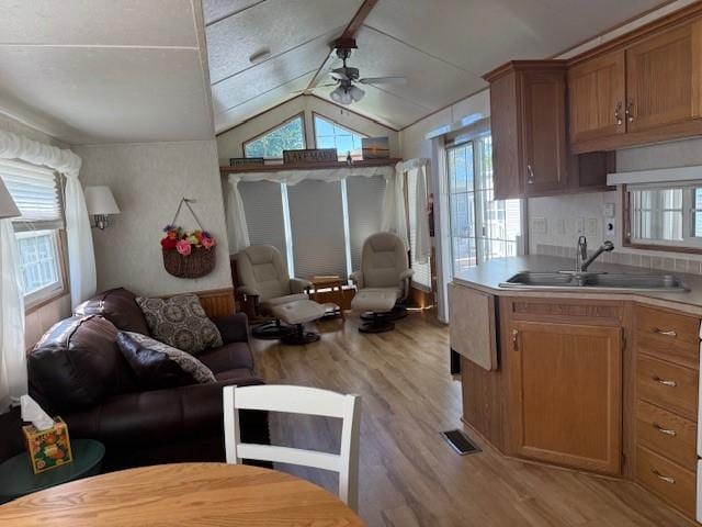 5055 Lake Mary Dr SW Unit 18, Alexandria, MN 56308 - living area featuring light wood finished floors, a ceiling fan, and lofted ceiling
