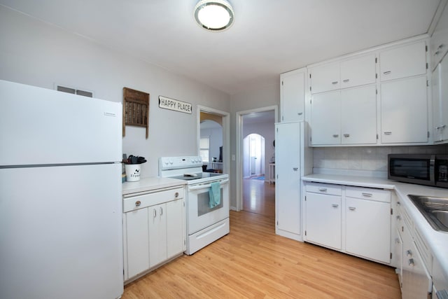202 Silver St E, Mapleton, MN 56065 - kitchen with white appliances, arched walkways, light countertops, and light wood-type flooring