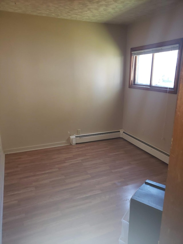 625 2nd Ave NE, Staples, MN 56479 - spare room featuring baseboard heating, wood finished floors, and a textured ceiling