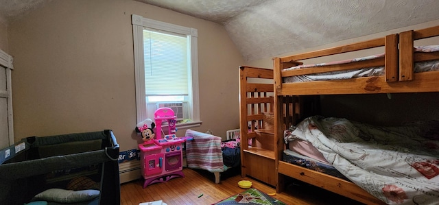 625 2nd Ave NE, Staples, MN 56479 - bedroom with lofted ceiling, hardwood / wood-style floors, cooling unit, and a textured ceiling