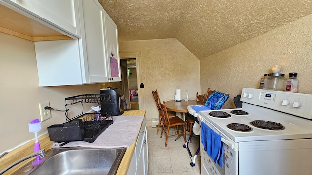 625 2nd Ave NE, Staples, MN 56479 - kitchen with white electric range, a textured wall, vaulted ceiling, white cabinetry, and light countertops