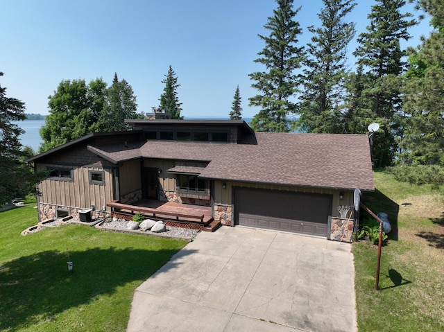 1938 Pine Cliff Rd NW, Walker, MN 56484 - view of front of house with stone siding, driveway, an attached garage, a front yard, and board and batten siding
