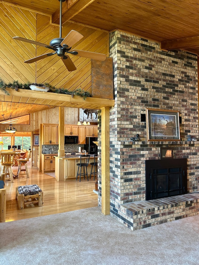 1938 Pine Cliff Rd NW, Walker, MN 56484 - living room featuring a wood ceiling with exposed beams, wood walls, a ceiling fan, a brick fireplace, and light wood-style flooring