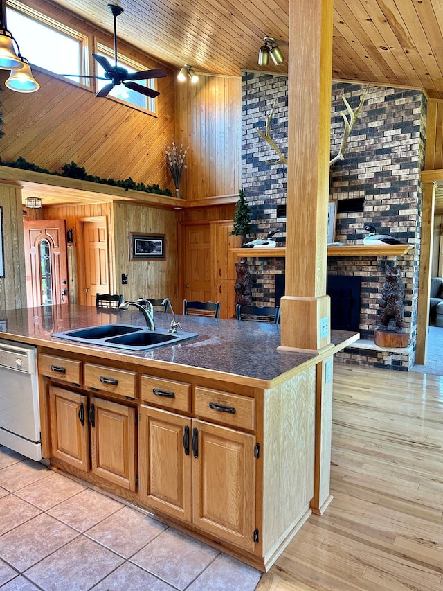 1938 Pine Cliff Rd NW, Walker, MN 56484 - kitchen with high vaulted ceiling, dishwasher, wooden walls, a brick fireplace, and a ceiling fan