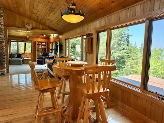 1938 Pine Cliff Rd NW, Walker, MN 56484 - dining space with vaulted ceiling, wood walls, light wood finished floors, and built in shelves