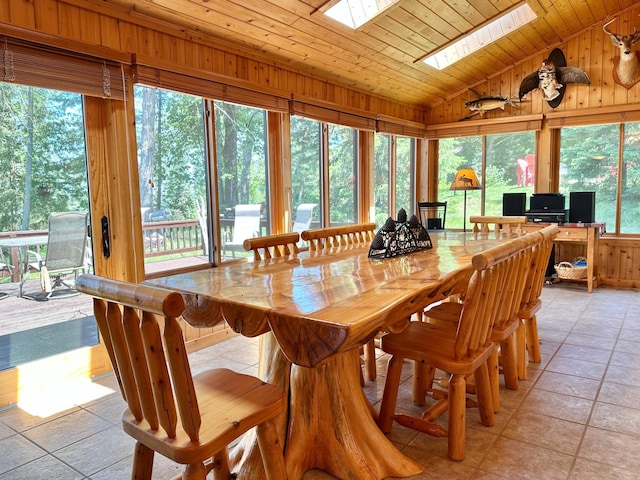 1938 Pine Cliff Rd NW, Walker, MN 56484 - dining space featuring lofted ceiling, a skylight, wood ceiling, light tile patterned flooring, and wooden walls