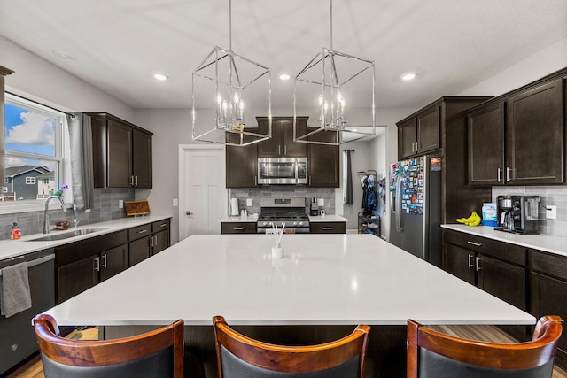 4617 Cobalt Ln, Woodbury, MN 55129 - kitchen featuring stainless steel appliances, decorative backsplash, a kitchen island, light countertops, and a breakfast bar