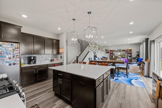 4617 Cobalt Ln, Woodbury, MN 55129 - kitchen with freestanding refrigerator, gas range, light wood finished floors, light countertops, and tasteful backsplash