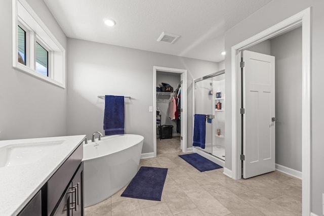 4617 Cobalt Ln, Woodbury, MN 55129 - full bath featuring a walk in closet, a shower stall, a freestanding bath, recessed lighting, and vanity