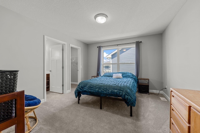 4617 Cobalt Ln, Woodbury, MN 55129 - bedroom with light colored carpet, a textured ceiling, and a walk in closet