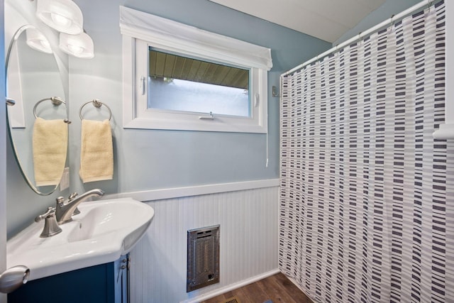 68018 217th St, Ellsworth Twp, MN 55324 - full bath with wood finished floors, vanity, wainscoting, and curtained shower