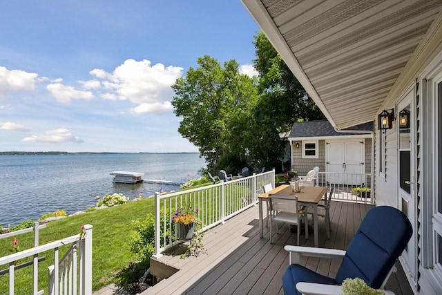 68018 217th St, Ellsworth Twp, MN 55324 - wooden deck with outdoor dining space, a water view, and a lawn