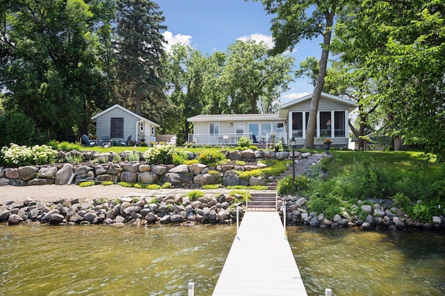 68018 217th St, Ellsworth Twp, MN 55324 - back of property with a sunroom, stairs, and a water view