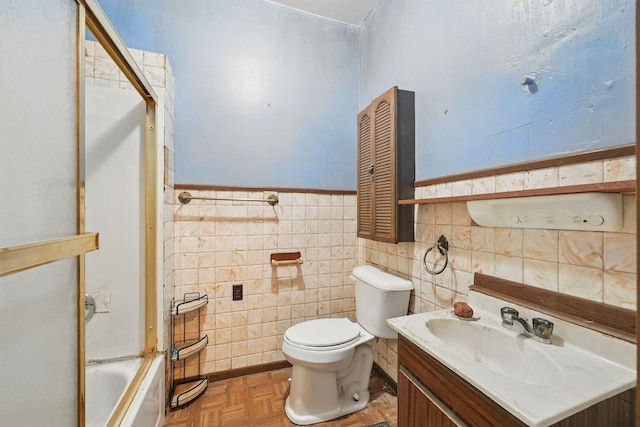 2918 15th Ave S, Minneapolis, MN 55407 - bathroom featuring vanity, a wainscoted wall, bath / shower combo with glass door, and tile walls