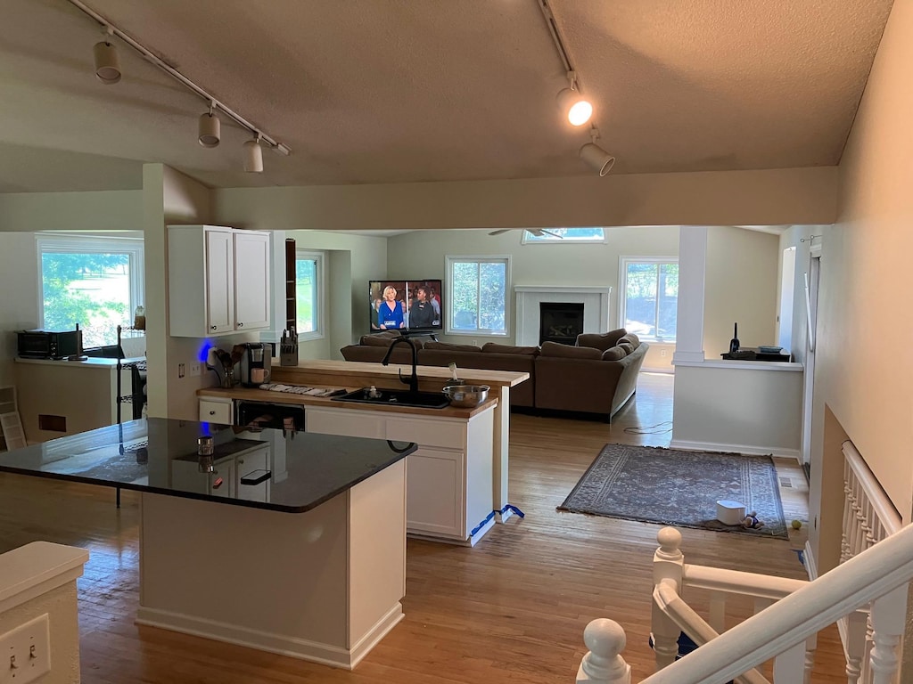 14405 Drumlin Ct, Apple Valley, MN 55124 - kitchen featuring track lighting, white cabinets, a center island, dark countertops, and a textured ceiling