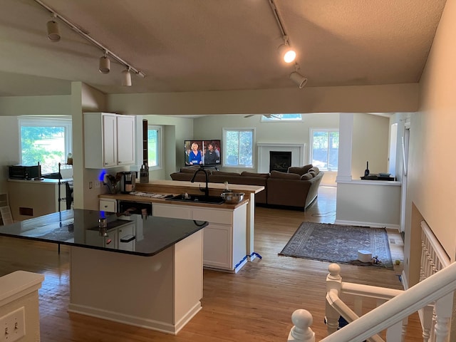 14405 Drumlin Ct, Apple Valley, MN 55124 - kitchen featuring track lighting, white cabinets, a center island, dark countertops, and a textured ceiling