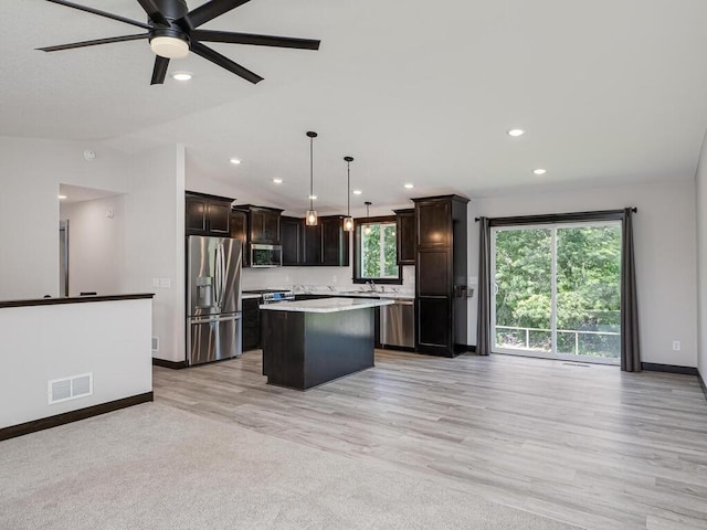 1049 Bellaire Blvd NW, Isanti, MN 55040 - kitchen featuring appliances with stainless steel finishes, a center island, ceiling fan, light countertops, and light wood-style floors