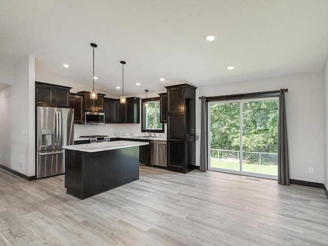 1049 Bellaire Blvd NW, Isanti, MN 55040 - kitchen with stainless steel appliances, light wood-style flooring, a center island, light countertops, and dark brown cabinetry