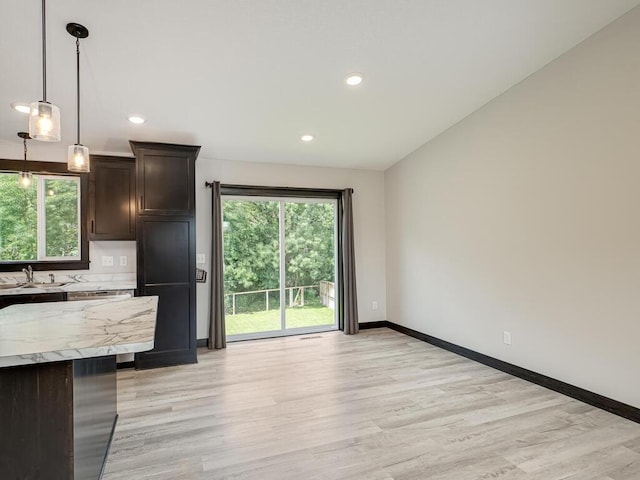 1049 Bellaire Blvd NW, Isanti, MN 55040 - kitchen featuring dark brown cabinets, light wood-style floors, hanging light fixtures, recessed lighting, and decorative backsplash