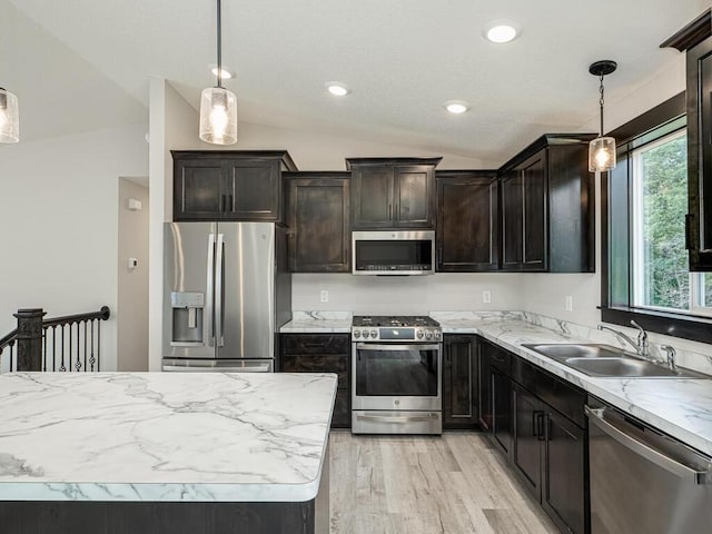 1049 Bellaire Blvd NW, Isanti, MN 55040 - kitchen featuring stainless steel appliances, vaulted ceiling, light wood-style floors, decorative light fixtures, and dark brown cabinets