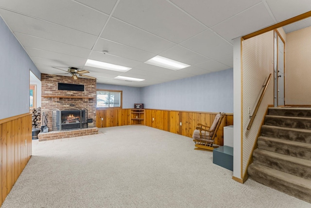 4885 262nd St, Wyoming, MN 55092 - unfurnished living room with carpet, stairway, a brick fireplace, a wainscoted wall, and wooden walls
