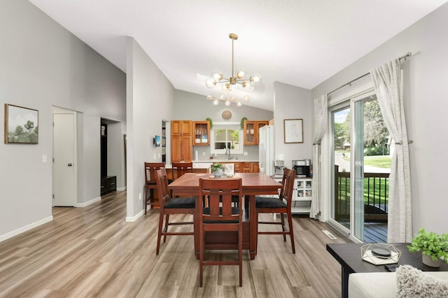 14301 Princeton Ave, Savage, MN 55378 - dining room with a chandelier, light wood-style flooring, and high vaulted ceiling
