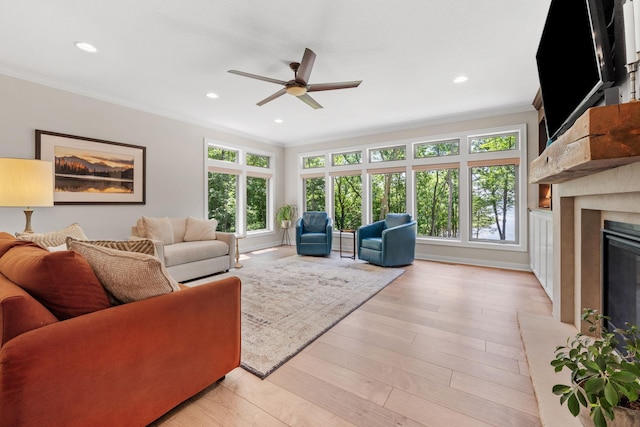 21386 Dorothy Way, Spring Lake Twp, MN 55372 - living room featuring ornamental molding, healthy amount of natural light, ceiling fan, a fireplace with raised hearth, and light wood-style flooring