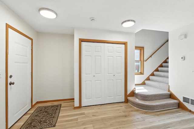 726 Thomas Ave, Saint Paul, MN 55104 - entrance foyer with light wood finished floors and stairway