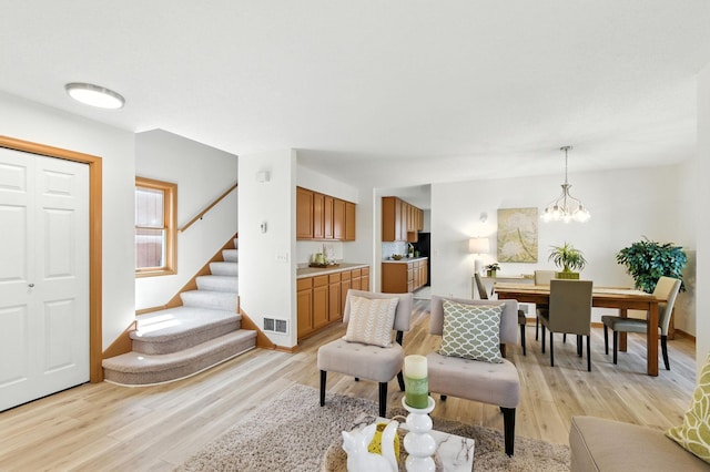 726 Thomas Ave, Saint Paul, MN 55104 - living area with stairs, light wood-style floors, and a chandelier