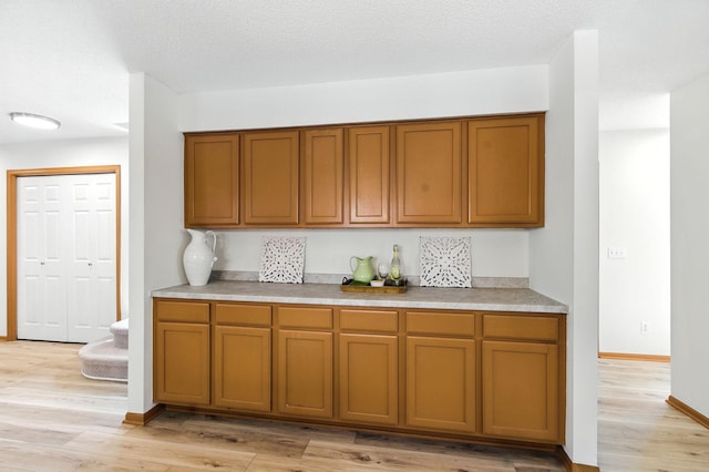 726 Thomas Ave, Saint Paul, MN 55104 - kitchen with brown cabinetry, light wood-type flooring, and light countertops