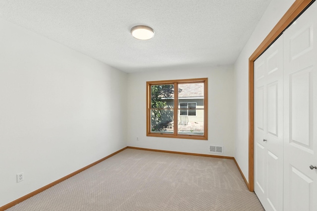 726 Thomas Ave, Saint Paul, MN 55104 - unfurnished bedroom with a closet, light carpet, and a textured ceiling