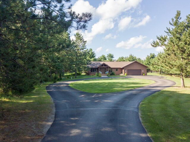 32433 Cedar St, Breezy Point, MN 56472 - view of front of house with asphalt driveway, a garage, and a front lawn