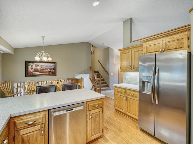 1483 Woods Creek Dr, Delano, MN 55328 - kitchen featuring appliances with stainless steel finishes, light wood-style flooring, lofted ceiling, light countertops, and a chandelier