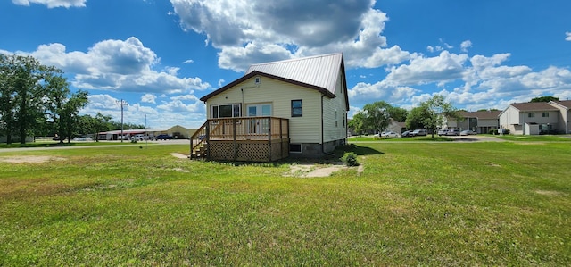 1402 3rd St NE, Staples, MN 56479 - view of property exterior featuring a yard, french doors, a metal roof, a wooden deck, and a residential view