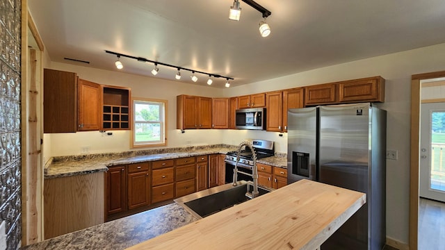 1402 3rd St NE, Staples, MN 56479 - kitchen with stainless steel appliances, rail lighting, brown cabinetry, and open shelves
