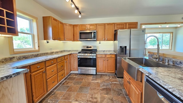1402 3rd St NE, Staples, MN 56479 - kitchen with appliances with stainless steel finishes, dark stone finish flooring, and brown cabinetry
