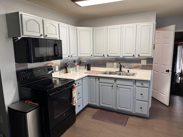 40149 181st St, Mickinock Twp, MN 56761 - kitchen with black appliances, gray cabinets, decorative backsplash, dark wood-type flooring, and white cabinetry