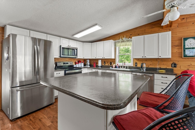 17053 490th St, Shamrock Twp, MN 55760 - kitchen with appliances with stainless steel finishes, lofted ceiling, dark countertops, dark wood finished floors, and white cabinets