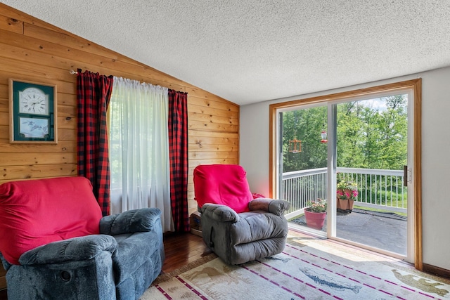 17053 490th St, Shamrock Twp, MN 55760 - living area with vaulted ceiling, wood walls, a textured ceiling, and wood finished floors