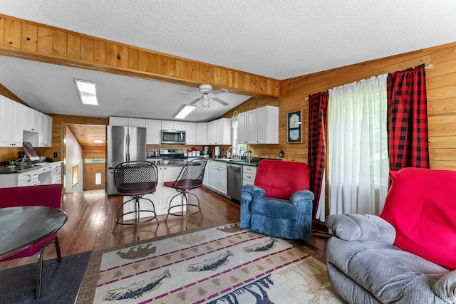 17053 490th St, Shamrock Twp, MN 55760 - living area with wood walls, dark wood-style flooring, a textured ceiling, and ceiling fan