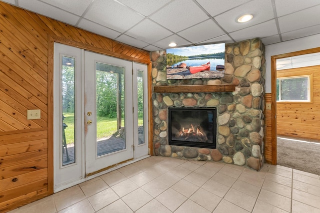 17053 490th St, Shamrock Twp, MN 55760 - doorway to outside featuring light tile patterned flooring, wooden walls, a fireplace, a paneled ceiling, and recessed lighting