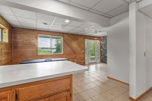 17053 490th St, Shamrock Twp, MN 55760 - kitchen with a drop ceiling, wood walls, light tile patterned floors, light countertops, and brown cabinets