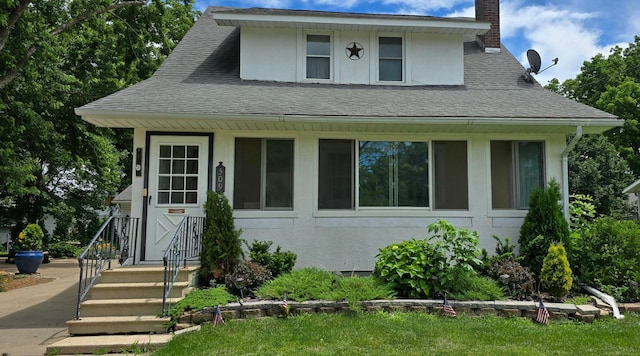 309 5th St SW, Austin, MN 55912 - view of front of home featuring stucco siding, a chimney, and a shingled roof