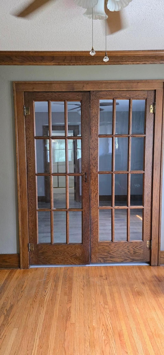 309 5th St SW, Austin, MN 55912 - detailed view of french doors, wood finished floors, crown molding, a textured ceiling, and ceiling fan